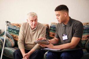Therapeutic Recreation Therapist sitting with resident