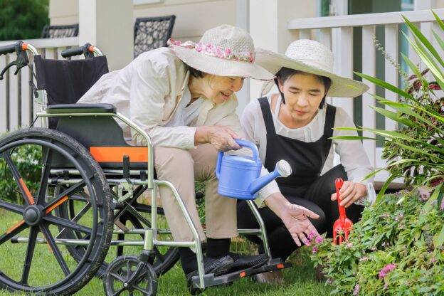 daughter gardening with mother who is in a wheelchair