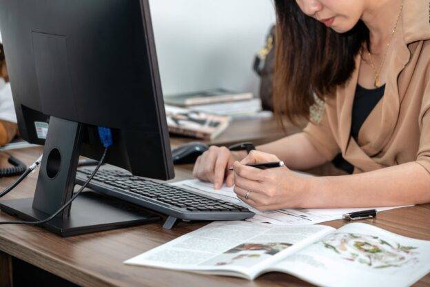 woman infront of a computer completing a form